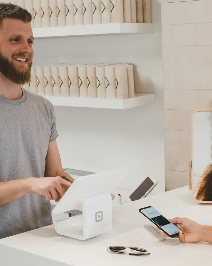 Een winkelier rekent af met een klant die met haar telefoon betaalt