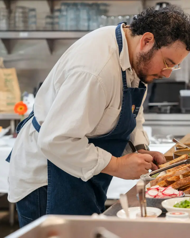 Een kok legt gerechten klaar op een buffet
