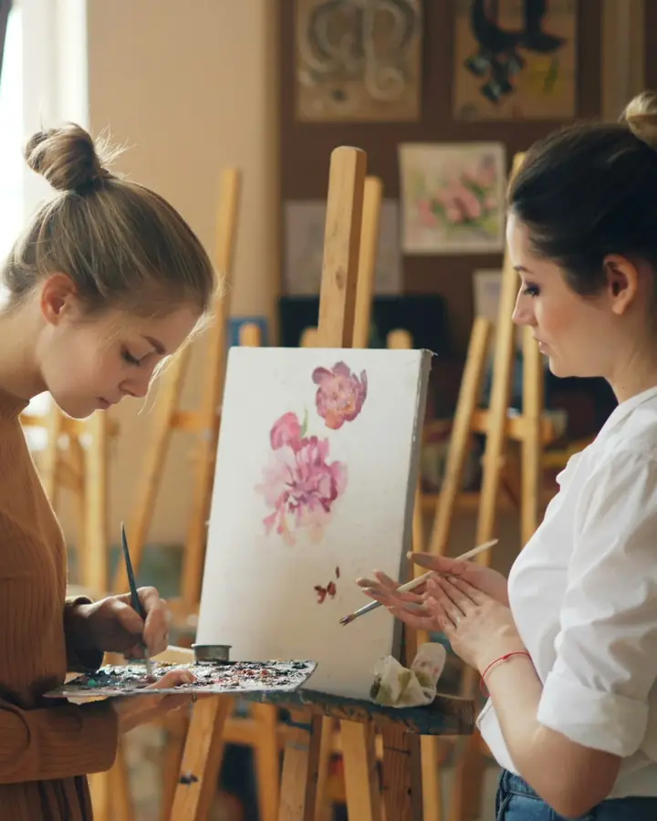 Twee vrouwen schilderen samen in een atelier