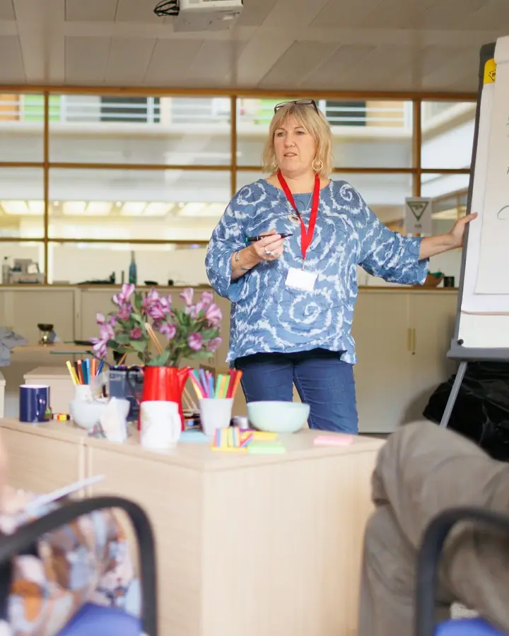Een docent geeft uitleg aan een groep cursisten
