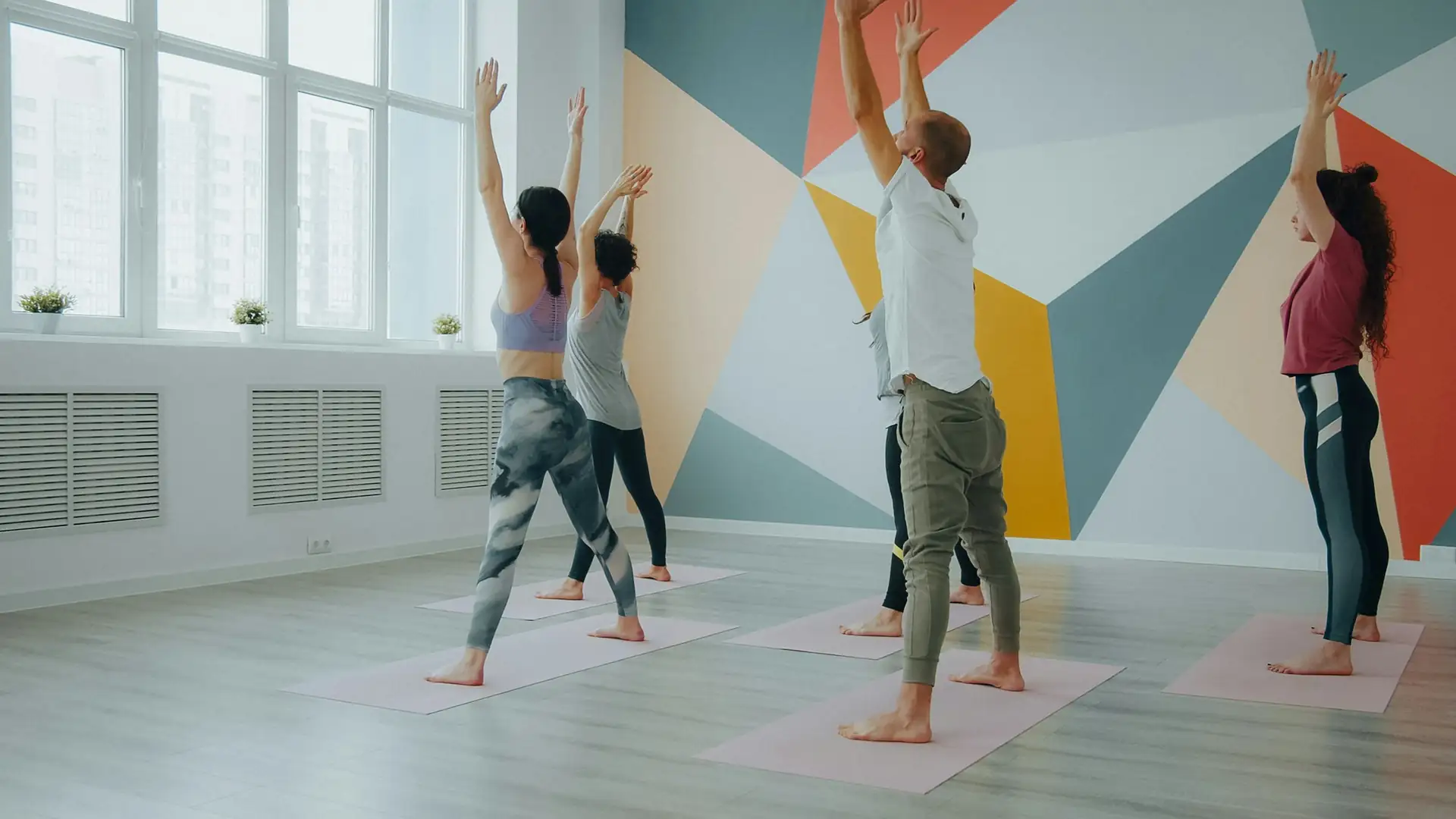 Een groep doet yoga in een lichte studio