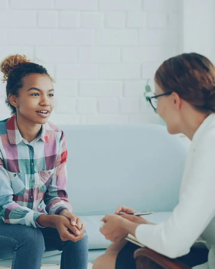 Een therapeut in gesprek met een cliënt op een bank