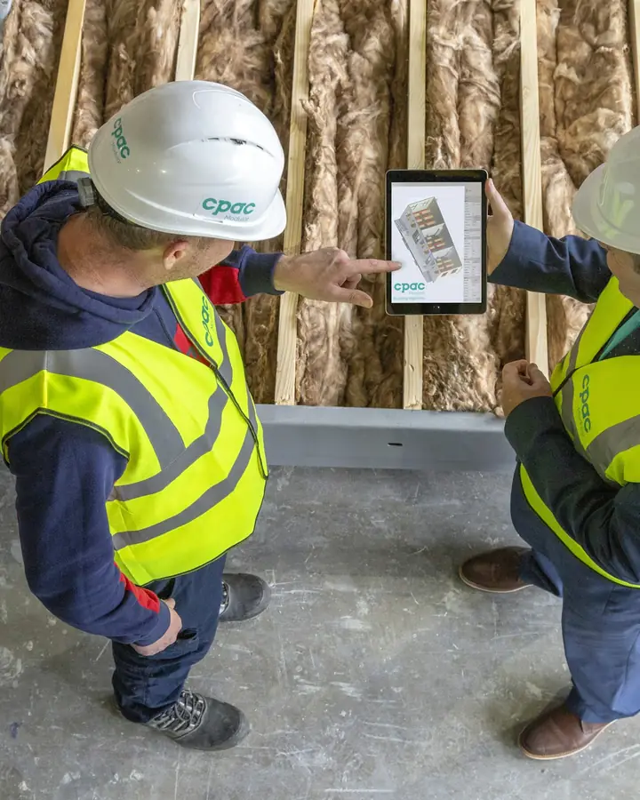 Twee bouwvakkers bekijken samen een tekening op een tablet