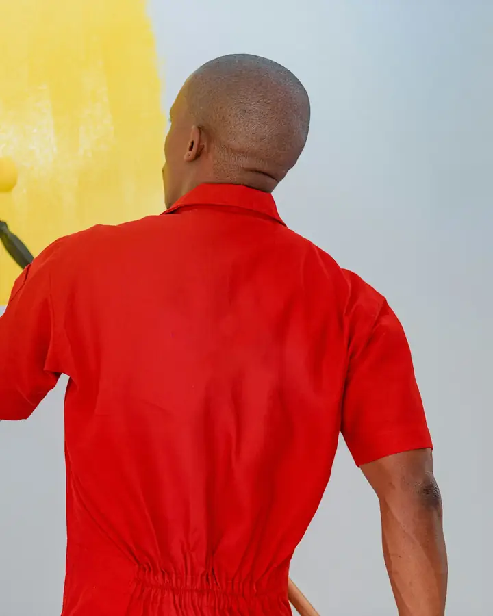 Een schilder zet een muur in de gele verf
