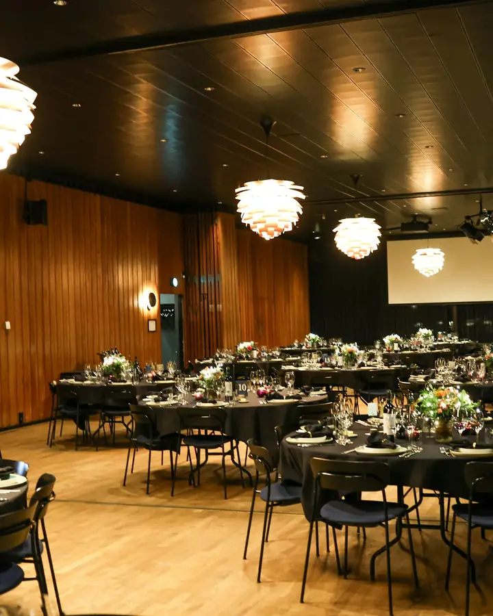 Een zaal met gedekte ronde tafels