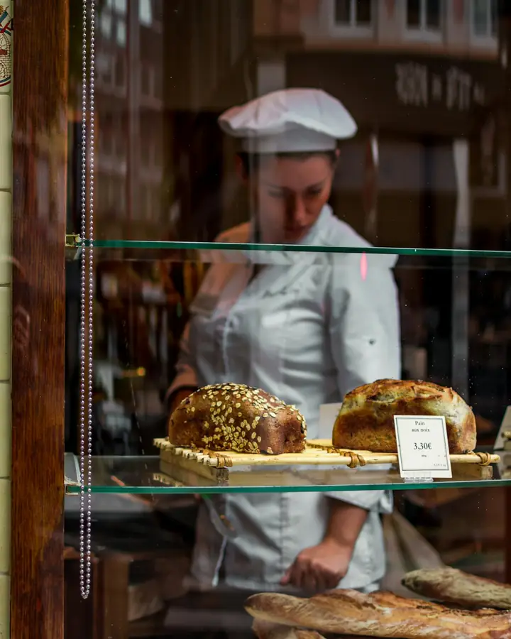 Een bakker zet brood in de vitrine van zijn winkel